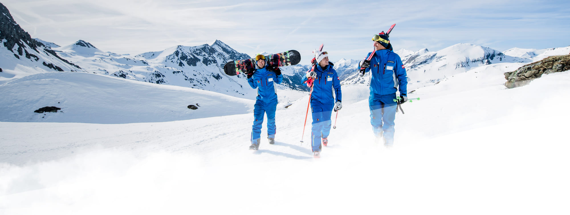 3 Teammitglieder gehen auf der Skipiste im Skigebiet Obertauern